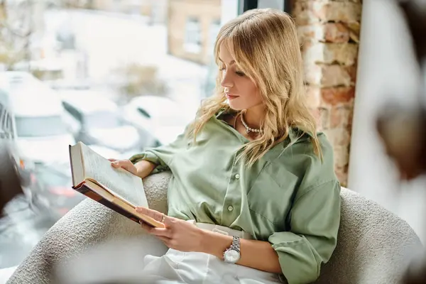 Femme relaxante avec un livre dans une cuisine ensoleillée. — Photo de stock