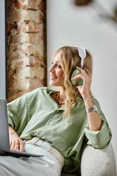 Una donna seduta su un divano, impegnata in una conversazione telefonica. — Foto stock