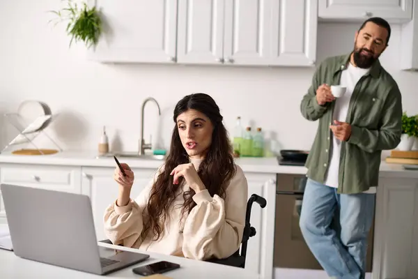 Beautiful woman with mobility disability having video call near her bearded husband drinking coffee — Stock Photo