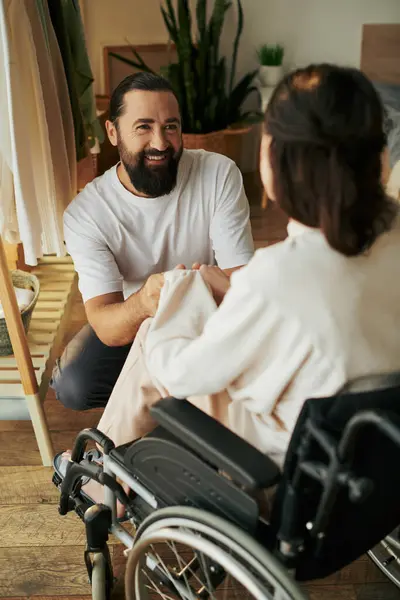 Bom olhar alegre homem passar tempo com sua bela esposa deficiente, enquanto no quarto em casa — Fotografia de Stock