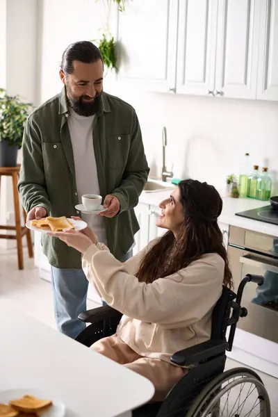 Homem amoroso barbudo trazendo sua esposa alegre com brindes de deficiência e café quente no café da manhã — Fotografia de Stock