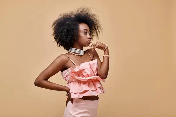 Pretty african american girl in 20s posing in peach ruffle top and pastel skirt with hand on hip — Stock Photo