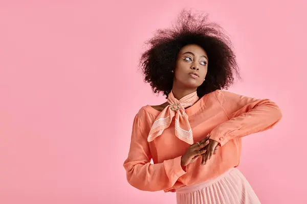 Mulher americana africana sonhadora em blusa de pêssego, saia midi e cachecol pescoço posando em pano de fundo rosa — Fotografia de Stock