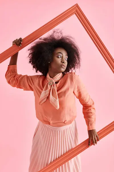 Sonhador menina americana africana em pêssego fuzz blusa e saia da moda posando no quadro no fundo rosa — Fotografia de Stock