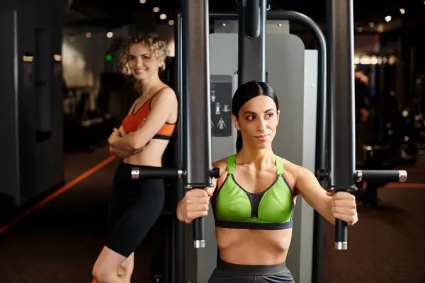 Concentre-se em treinador feminino mostrando ao seu atraente cliente desfocado como usar a máquina de imprensa no peito — Fotografia de Stock