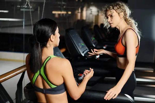 Gut aussehende sportliche Trainerin und ihr blonder Kunde in Sportbekleidung beim Training auf dem Laufband im Fitnessstudio — Stockfoto
