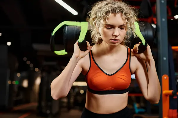 Good looking blonde woman in cozy sportwear exercising actively with power bag while in gym — Stock Photo