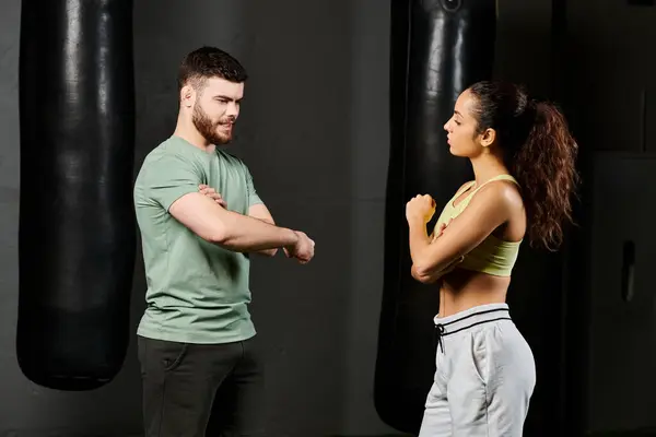 Entrenador masculino enseña técnicas de autodefensa a la mujer en el gimnasio. - foto de stock