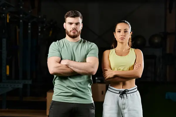 Un entrenador masculino enseñando técnicas de autodefensa a una mujer en un gimnasio, ambos de pie con confianza uno al lado del otro. - foto de stock
