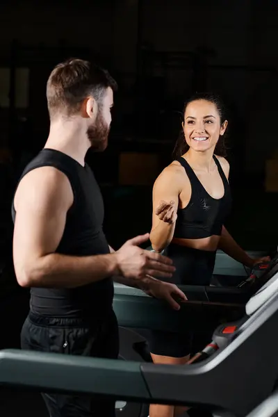Personal trainer motivates brunette sportswoman on a treadmill in a gym setting, striving for fitness goals. — Stock Photo