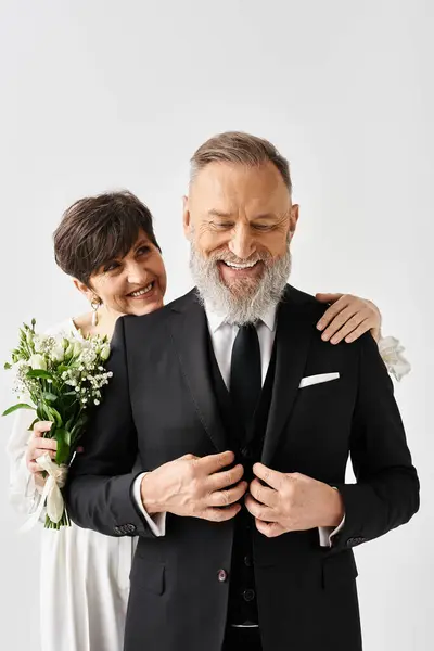 A middle-aged bride and groom in wedding attire, celebrating their special day in a studio setting. — Stock Photo