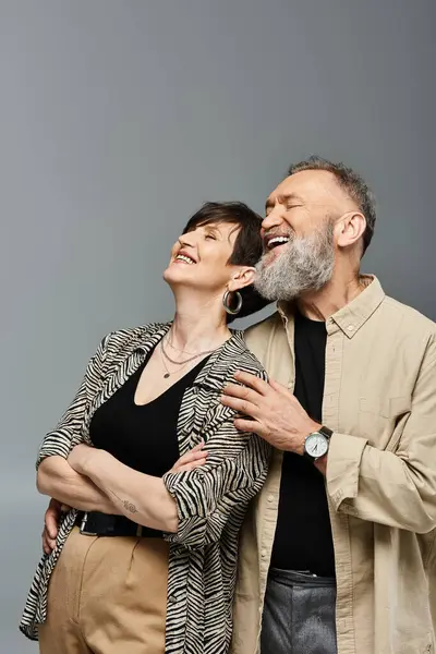 A middle-aged couple stands side by side, exuding style and grace in a studio setting. They emanate a sense of unity and sophistication. — Stock Photo