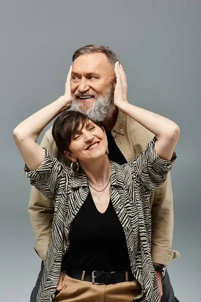 A middle-aged man and woman in stylish attire sit closely together, exuding an air of unity and tranquility. — Stock Photo