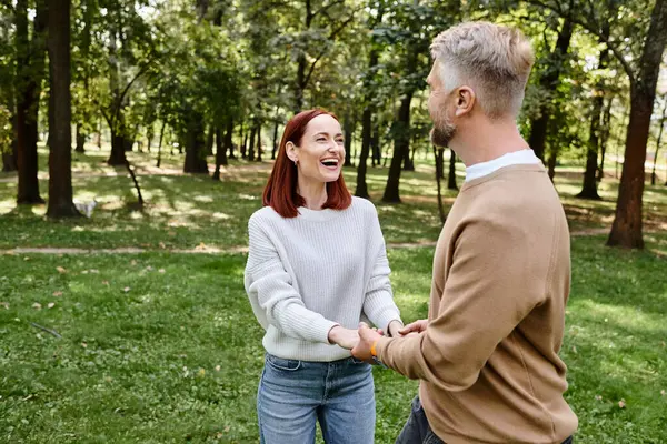 Чоловік і жінка тримають руки на прогулянці парком. — стокове фото