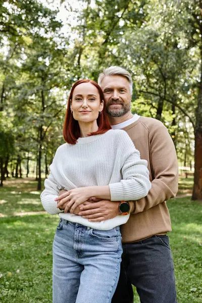 Couple adulte en tenue décontractée debout ensemble dans un parc. — Photo de stock