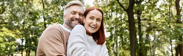 A man and a woman in the woods, smiling lovingly on a walk. — Stock Photo