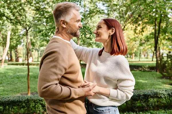 Un homme et une femme, un couple amoureux, debout ensemble dans un parc paisible. — Photo de stock