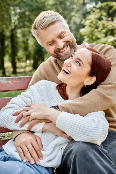 Um homem e uma mulher de traje casual sentados pacificamente em um banco em um parque. — Fotografia de Stock