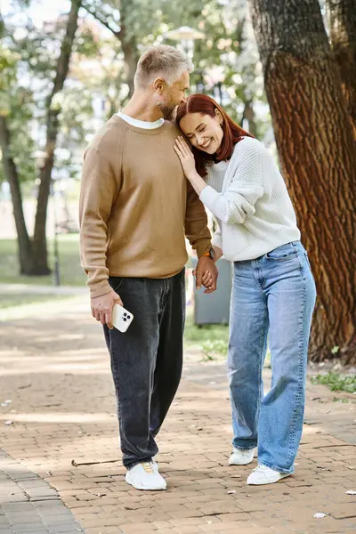 Adult loving couple in casual attire standing together in the park. — Stock Photo