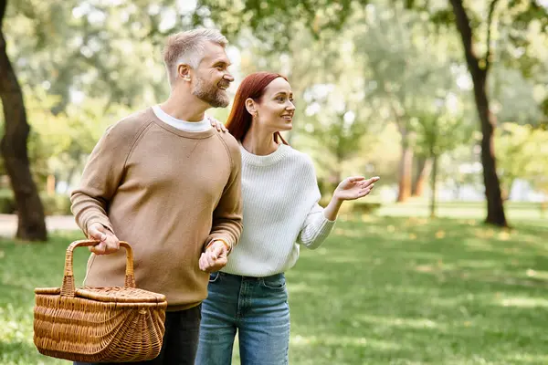 A couple in casual attire peacefully walking through a park. — Stock Photo