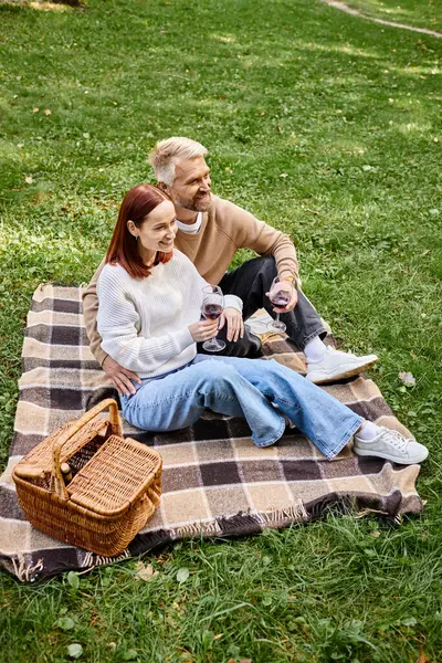 Мужчина и женщина наслаждаются мирным моментом на одеяле в траве. — стоковое фото