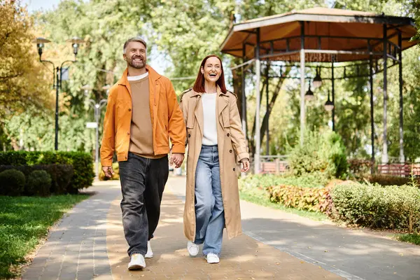 Casual couple enjoying a leisurely walk in the park. — Stock Photo