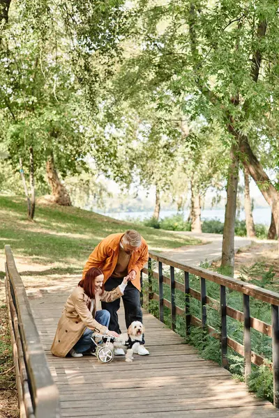 An adult man and a little girl standing on a bridge in a park. — Stock Photo