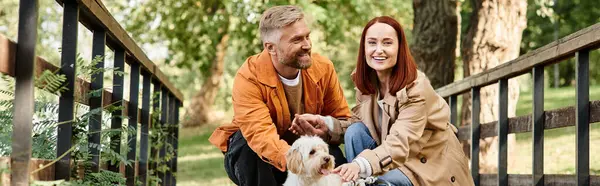 Adult couple enjoying a peaceful moment with their dog on a bridge. — Stock Photo