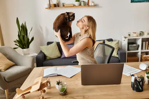 A woman with short hair holding her cat close to her face while at home. — Stock Photo
