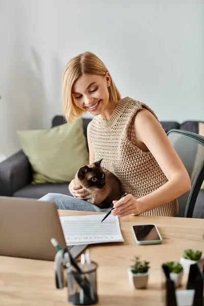 A woman with short hair sitting at a table, her cat peacefully resting on her lap as they share a moment of calm togetherness. — Stock Photo