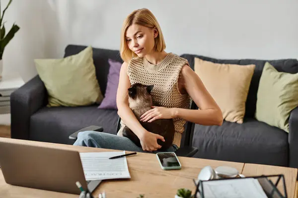 A woman with short hair sits on a couch, holding a cat in a serene moment of togetherness at home. — Stock Photo