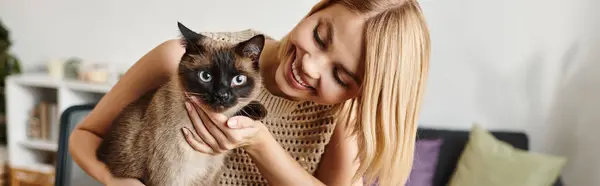 A woman with short hair lovingly holds her cat in her arms, showing a deep bond between them. — Stock Photo