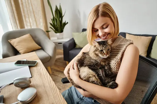 A short-haired woman peacefully holds her cat while sitting in a chair at home, forming a tranquil bond. — Stock Photo