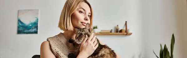 Une femme aux cheveux courts tient amoureusement son chat dans ses mains, collant et partageant un moment spécial ensemble à la maison. — Photo de stock