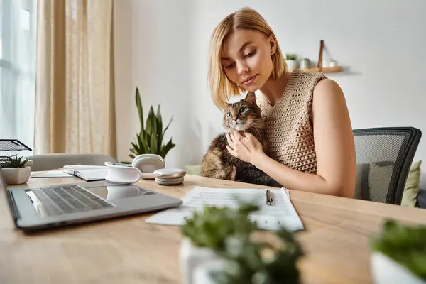 A woman with short hair sitting at a desk, peacefully holding her cat in a cozy home setting. — Stock Photo