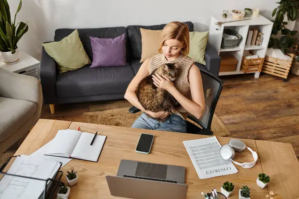A stylish woman with short hair relaxing in a chair, cradling her beloved cat in her arms at home. — Stock Photo