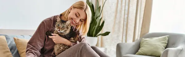 Uma mulher com cabelo curto carinhosamente segura seu gato em seus braços, mostrando afeto e vínculo entre humano e animal de estimação. — Fotografia de Stock