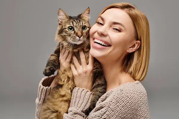 Uma mulher alegremente levanta seu gato para o rosto, ligando-se com seu companheiro peludo em casa. — Fotografia de Stock