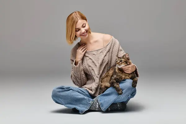 Жінка сидить на підлозі, обіймаючи свого кота ласкаво в тихий момент вдома. — стокове фото