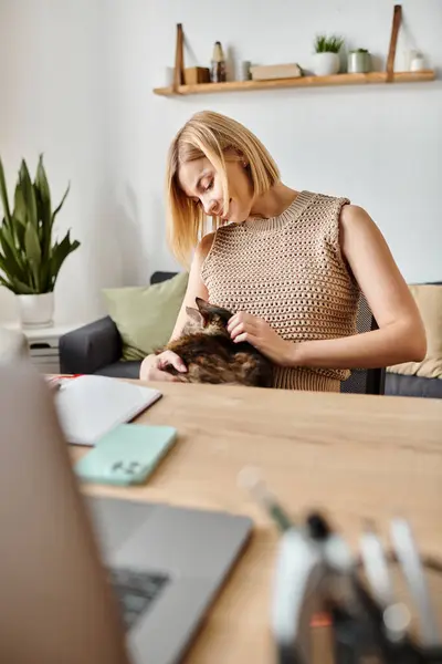 A woman with short hair is peacefully sitting at a table, gently petting her beloved cat in a cozy home setting. — Stock Photo