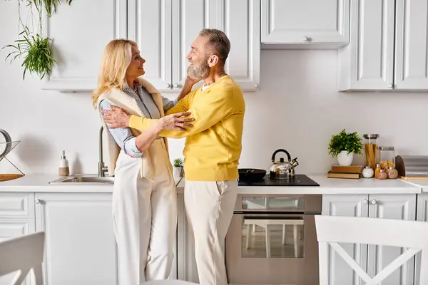 Maduro homem e mulher em casa aconchegante, amorosamente passar tempo juntos na cozinha em casa. — Fotografia de Stock