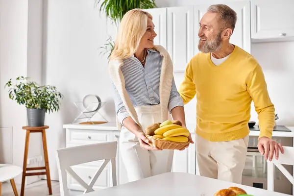 Un couple aimant mature dans des vêtements confortables passer du temps de qualité ensemble dans la cuisine à la maison. — Photo de stock