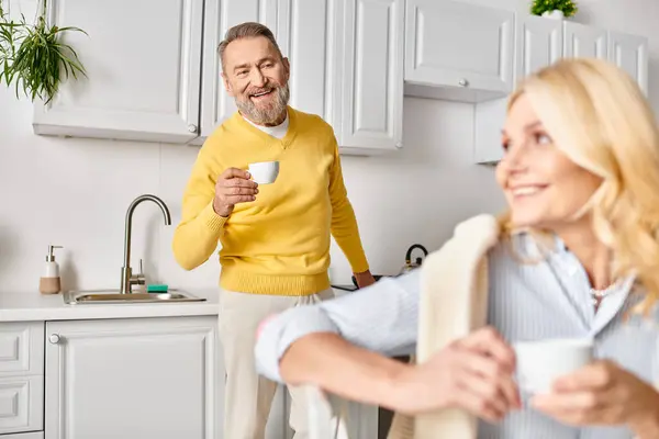 A mature loving couple in cozy homewear spending quality time together in a warm and inviting kitchen. — Stock Photo