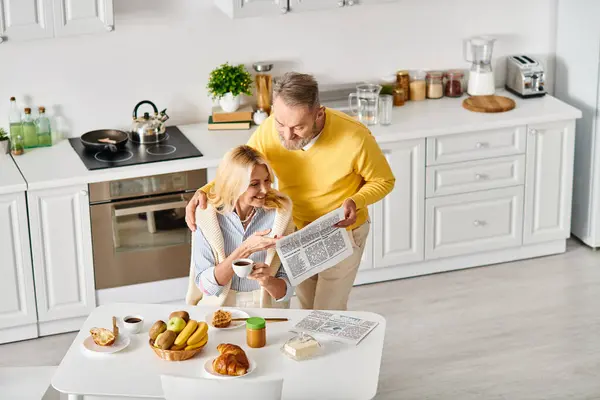 A mature loving couple in cozy homewear spending time together in the kitchen, creating delicious meals and cherished memories. — Stock Photo