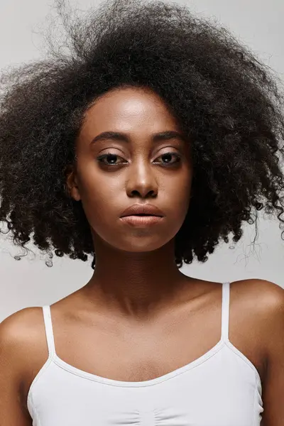 A stylish African American woman with a voluminous afro strikes a confident pose for a portrait in a studio setting. — Stock Photo