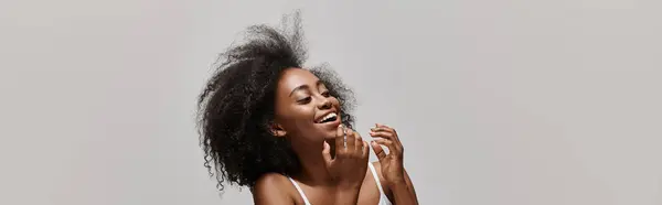 Молодая афроамериканка с вьющимися волосами в бикини в студии. — стоковое фото
