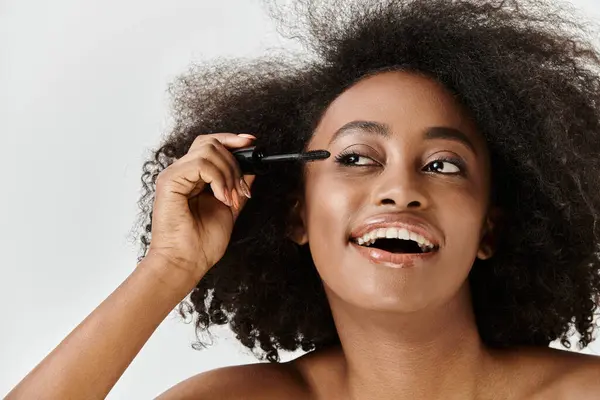 Uma bela jovem afro-americana com cabelo encaracolado, incorporando um conceito de beleza em um ambiente de estúdio. — Fotografia de Stock