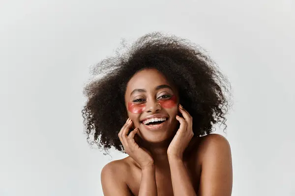 A young African American woman with curly hair in a studio setting, showcasing beauty and skin care — Stock Photo