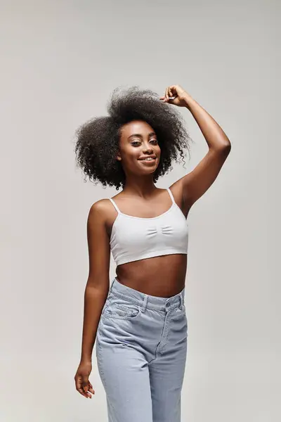 A stunning young African American woman with curly hair, styled in an afro, poses confidently for a camera. — Stock Photo