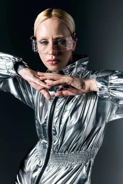 Mulher peculiar boa aparência em óculos futuristas olhando para a câmera no fundo cinza escuro — Fotografia de Stock